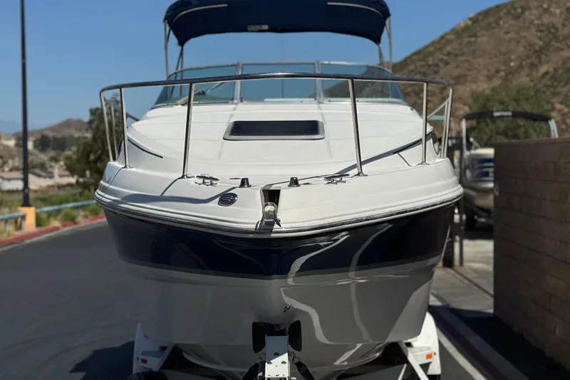 Slide: The Image of 2004 Chaparral Signature 260 boat on trailer, parked on a sunny street. - 2
