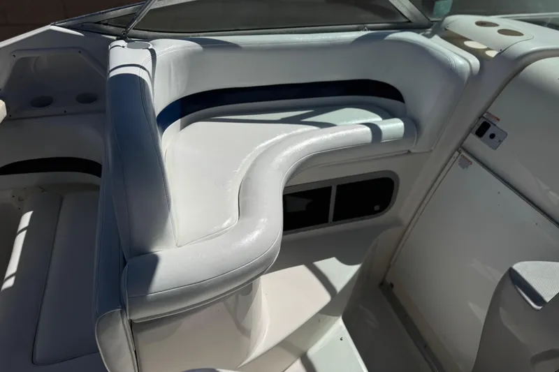 Slide: The Image of 2004 Chaparral Signature 260 boat interior with white seating and storage compartments. - 21