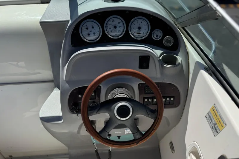 Slide: The Image of 2004 Chaparral Signature 260 boat dashboard with gauges and wooden steering wheel. - 24