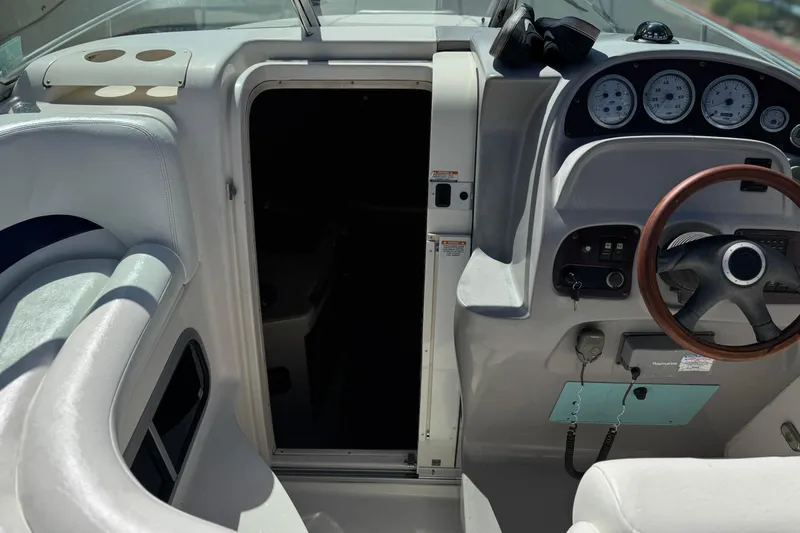 Slide: The Image of 2004 Chaparral Signature 260 boat cockpit with steering wheel and cabin entrance. - 27