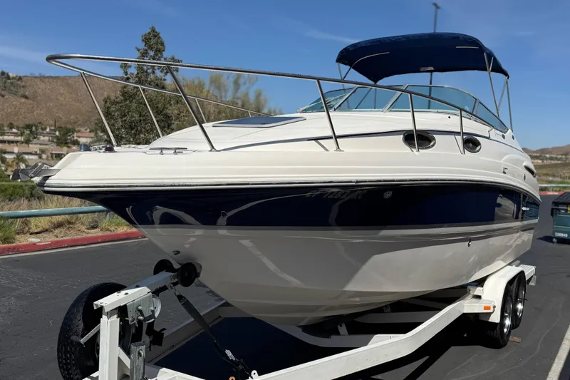 Slide: The Image of 2004 Chaparral Signature 260 boat on trailer, featuring sleek design and blue accents. - 3