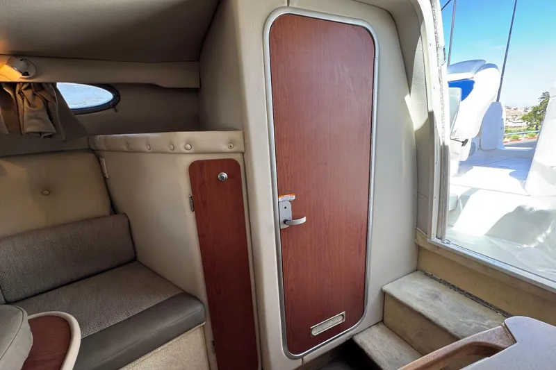 Slide: The Image of 2004 Chaparral Signature 260 cabin interior with seating and wooden door. - 35