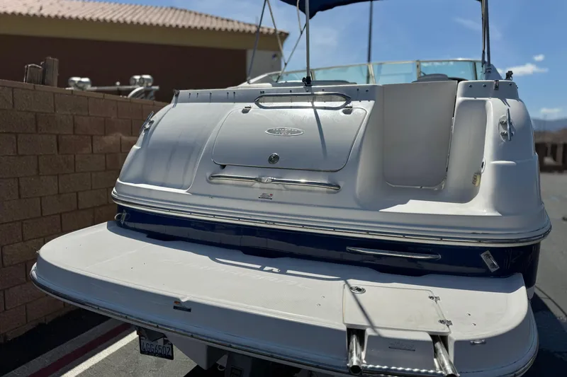 Slide: The Image of 2004 Chaparral Signature 260 boat, rear view, docked under clear blue sky. - 7