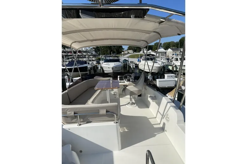 Slide: The Image of 2020 Beneteau Swift Trawler 35, spacious deck view at marina, featuring seating and helm. - 10