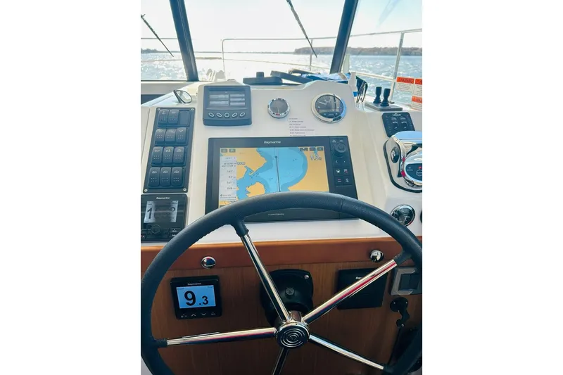 Slide: The Image of Helm of 2020 Beneteau Swift Trawler 35 with navigation equipment and steering wheel. - 12