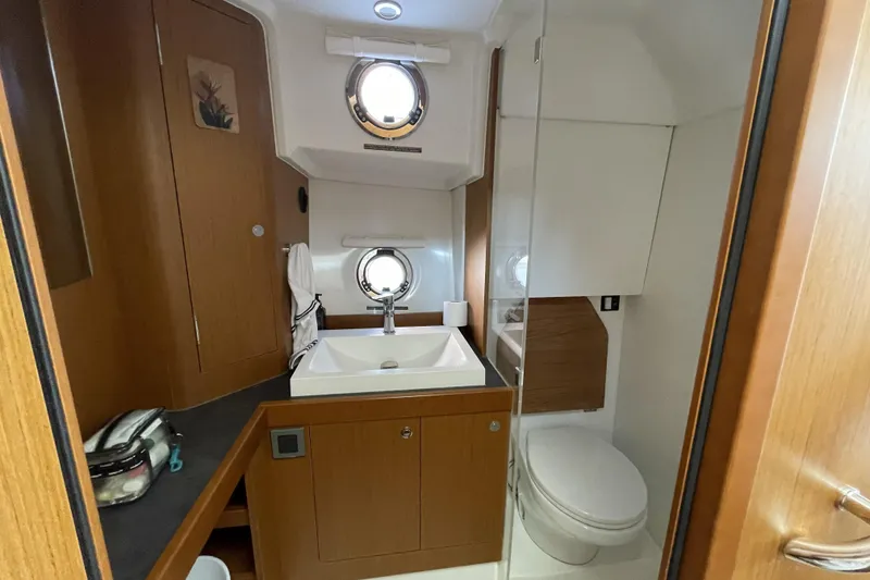 Slide: The Image of Modern bathroom in 2020 Beneteau Swift Trawler 35, featuring sink, toilet, and porthole window. - 14