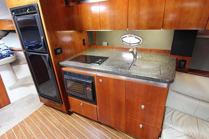 Slide: The Image of Luxurious 2007 Cruisers 420 yacht kitchen with wood cabinetry, stove, and microwave. - 12