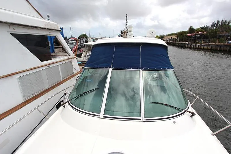Slide: The Image of 2007 Cruisers 420 yacht docked, featuring blue canopy and glass windshield. - 18
