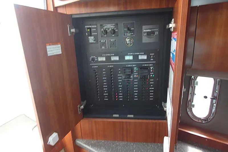 Slide: The Image of Electrical control panel inside a 2007 Cruisers 420 yacht, featuring circuit breakers and switches. - 4