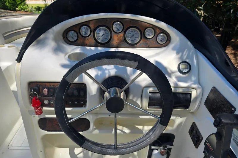 Slide: The Image of Steering console of a 2001 Smoker Craft 2310 Commander boat with gauges and controls. - 12