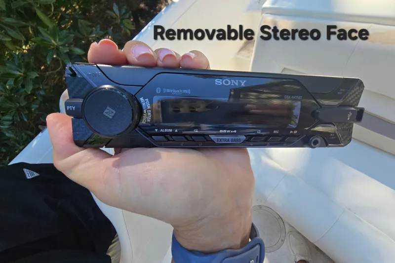 Slide: The Image of Hand holding Sony removable stereo face on Smoker Craft 2310 Commander boat. - 13