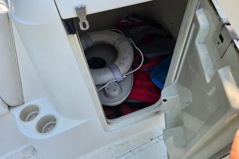 Slide: The Image of Storage compartment on a 2001 Smoker Craft 2310 Commander boat with life preserver and gear. - 21
