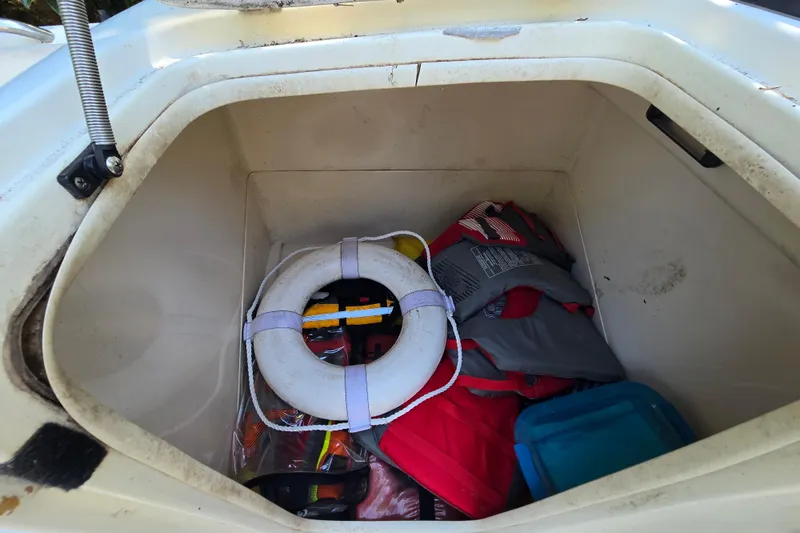 Slide: The Image of Storage compartment of 2001 Smoker Craft 2310 Commander with life jackets and a life ring. - 23