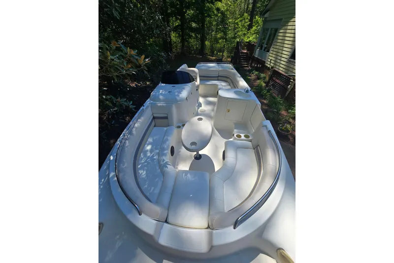 Slide: The Image of 2001 Smoker Craft 2310 Commander boat with spacious seating and table, surrounded by lush greenery. - 26