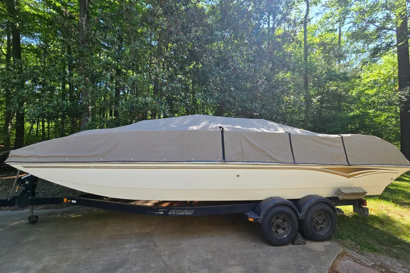 Slide: The Image of 2001 Smoker Craft 2310 Commander boat covered on trailer in wooded area. - 6