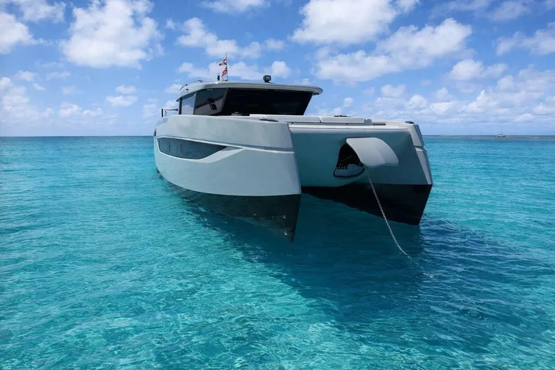 Slide: The Image of 2026 Sunreef Ultima catamaran anchored in clear turquoise waters under a bright blue sky. - 10