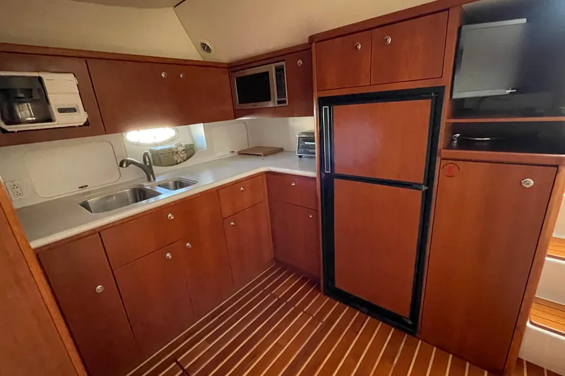 Slide: The Image of Luxurious 2002 Tiara Yachts 4100 Open galley with wood cabinetry and modern appliances. - 2
