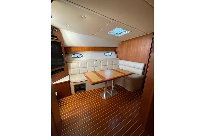 Slide: The Image of Interior of 2002 Tiara Yachts 4100 Open with wood flooring and cushioned seating. - 3