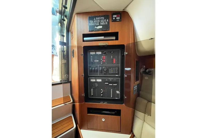 Slide: The Image of Electrical panel inside a 2002 Tiara Yachts 4100 Open, featuring wood accents and control switches. - 6