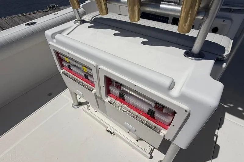 Slide: The Image of 2003 Robalo R230 Center Console boat with storage compartments and rod holders. - 10