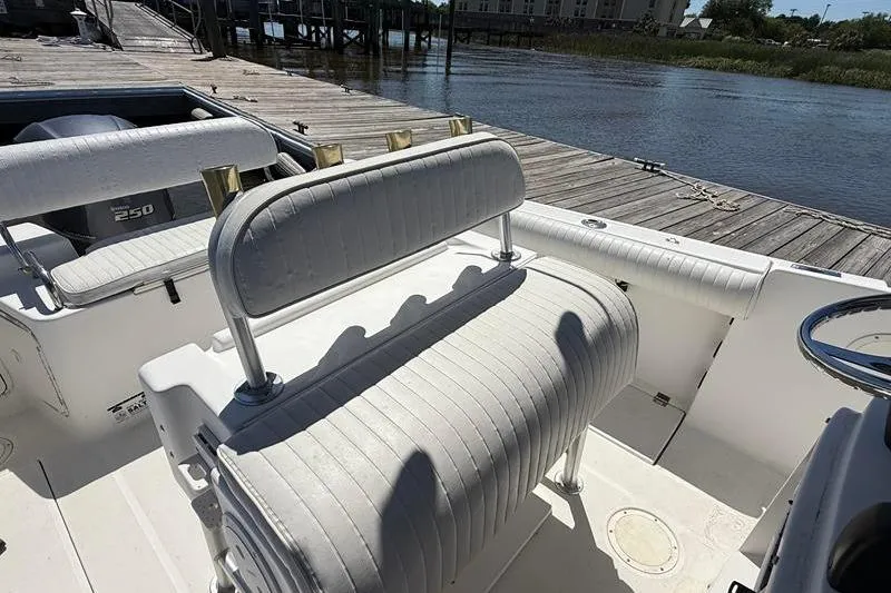 Slide: The Image of 2003 Robalo R230 Center Console boat interior with seating and dock view. - 13