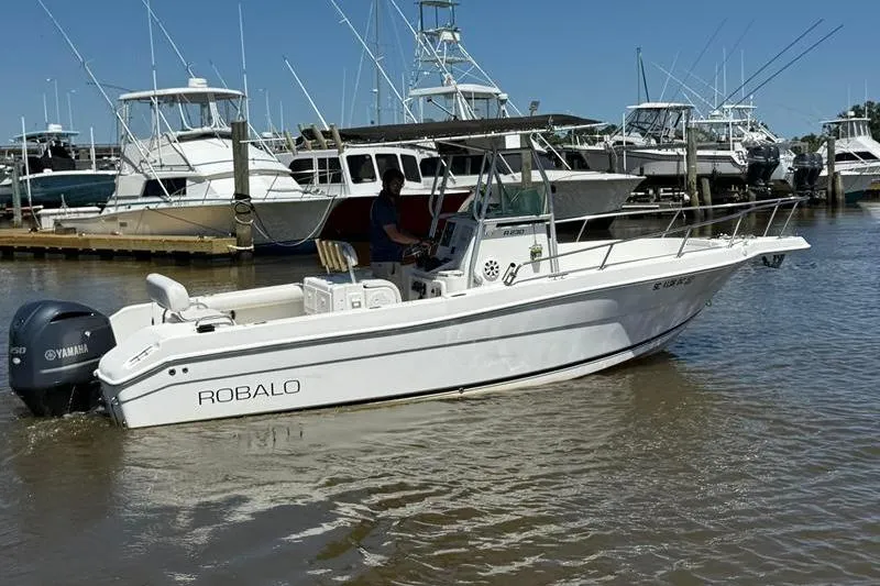 Slide: The Image of 2003 Robalo R230 Center Console boat docked in marina, featuring Yamaha outboard motor. - 2