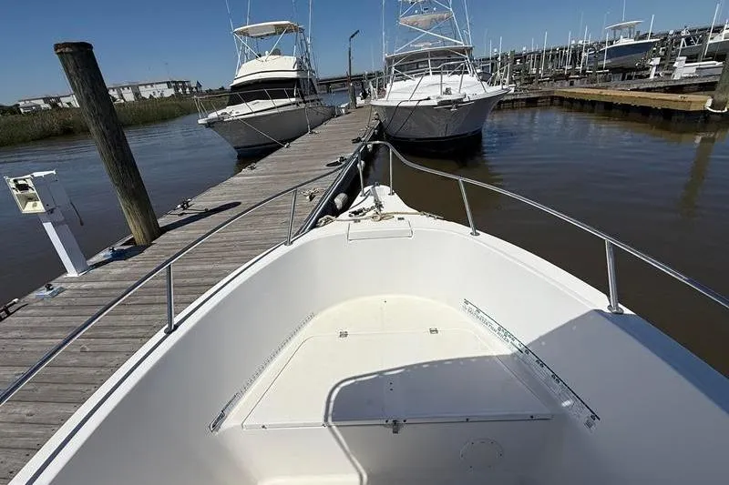 Slide: The Image of 2003 Robalo R230 Center Console boat docked at marina with other vessels. - 23