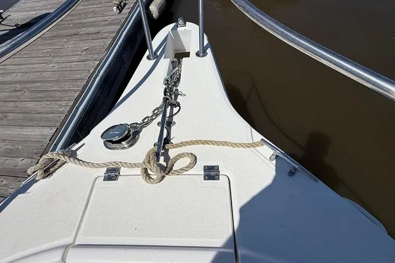 Slide: The Image of Bow of 2003 Robalo R230 Center Console boat docked with anchor chain and rope. - 25
