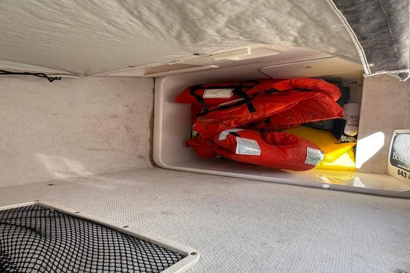 Slide: The Image of Storage compartment with life jackets on a 2003 Robalo R230 Center Console boat. - 27