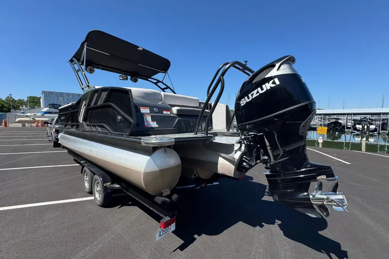 Slide: The Image of 2021 Crest RS250 pontoon boat with Suzuki outboard motor on trailer in marina parking lot. - 12