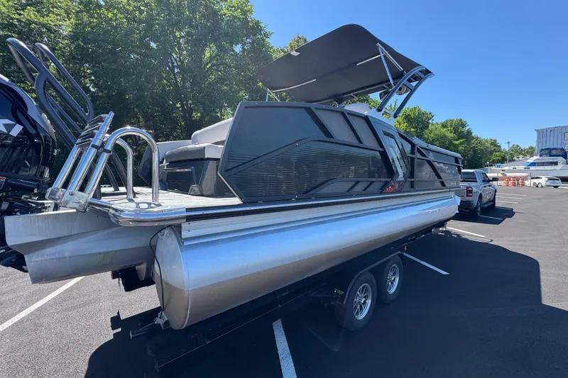 Slide: The Image of 2021 Crest RS250 pontoon boat on trailer, parked outdoors under clear blue sky. - 16