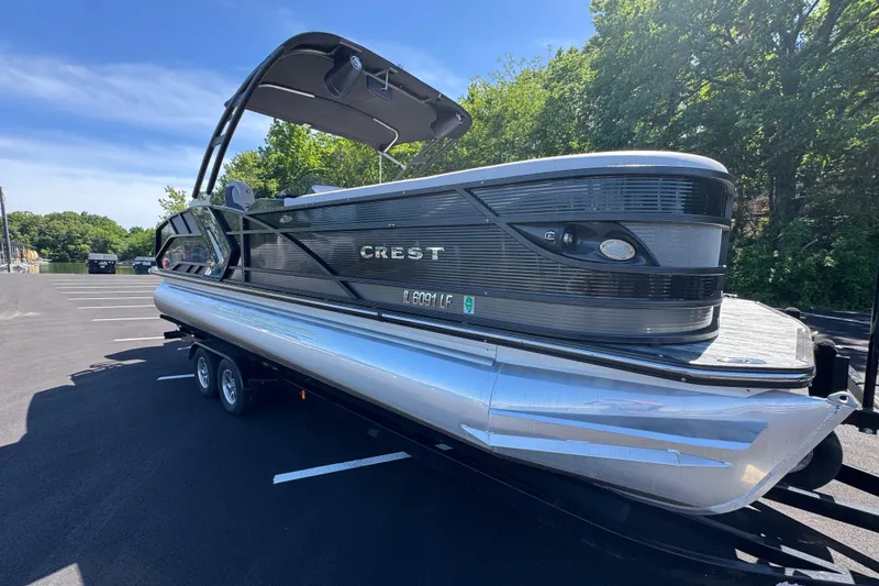 Slide: The Image of 2021 Crest RS250 pontoon boat on trailer in sunny parking lot. - 18