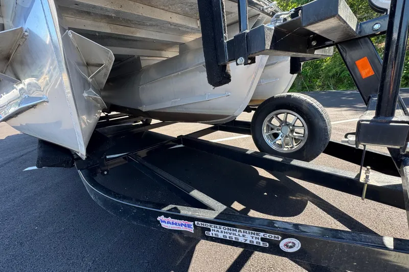 Slide: The Image of Trailer with Crest RS250 pontoon boat, 2021 model, parked on asphalt. - 19