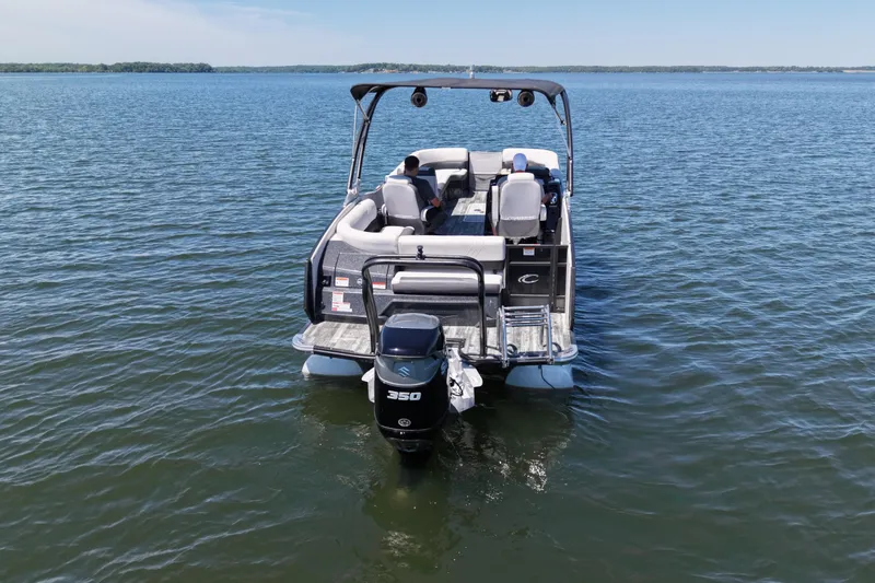 Slide: The Image of 2021 Crest RS250 pontoon boat on a calm lake, rear view with outboard motor. - 3