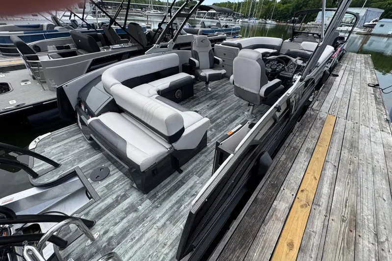 Slide: The Image of 2021 Crest RS250 pontoon boat with spacious seating, docked at a marina. - 38
