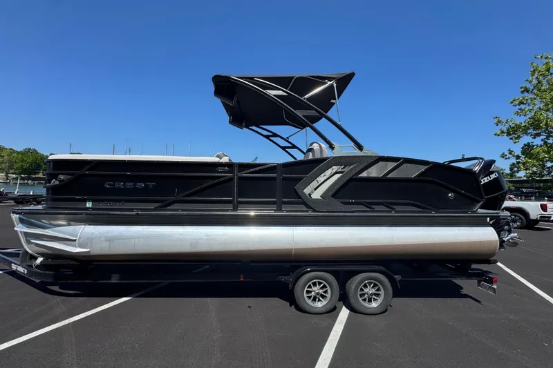 Slide: The Image of 2021 Crest RS250 pontoon boat on trailer, black exterior, parked in sunny lot. - 4
