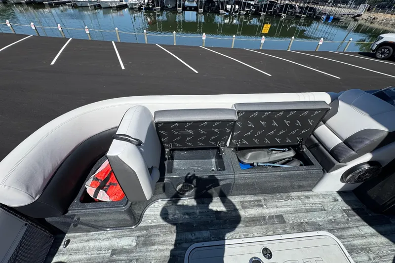 Slide: The Image of 2021 Crest RS250 boat interior with storage compartments and seating, docked near a marina. - 43