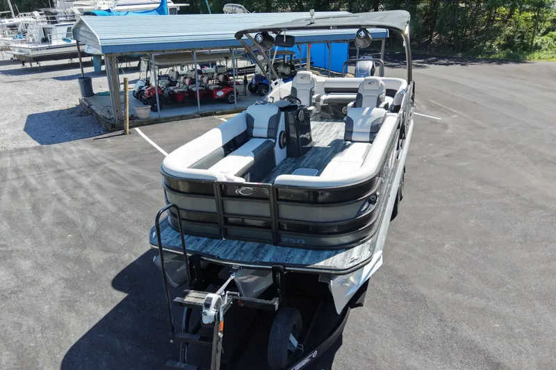 Slide: The Image of 2021 Crest RS250 pontoon boat parked on asphalt near covered storage area. - 7