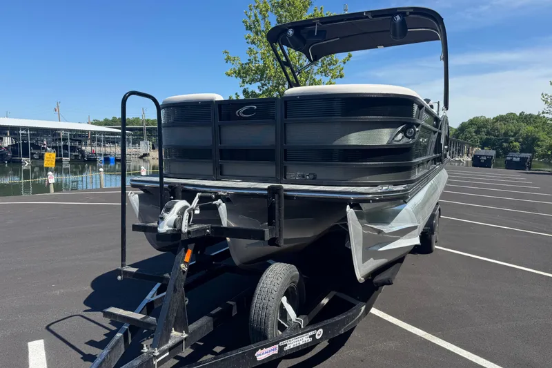 Slide: The Image of 2021 Crest RS250 pontoon boat on trailer in sunny parking lot near marina. - 9