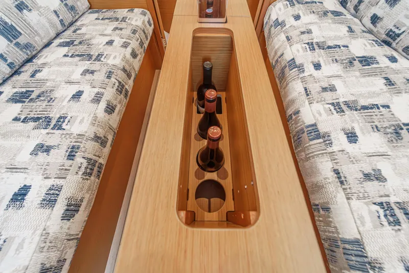 Slide: The Image of Interior of 2022 Jeanneau Sun Odyssey 349 with wine storage between cushioned seats. - 16