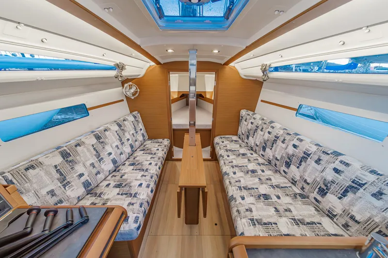 Slide: The Image of Interior of 2022 Jeanneau Sun Odyssey 349 sailboat with modern seating and wooden accents. - 17
