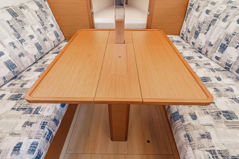 Slide: The Image of 2022 Jeanneau Sun Odyssey 349 interior with wooden table and patterned seating. - 18