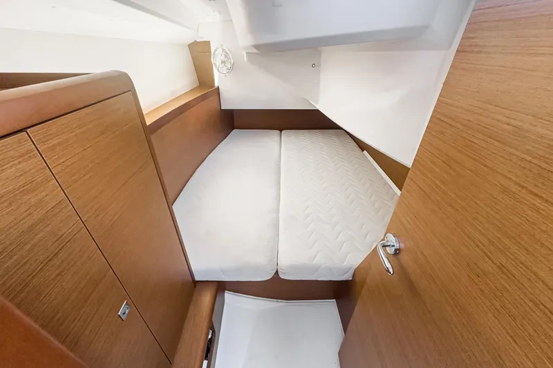 Slide: The Image of Interior cabin of 2022 Jeanneau Sun Odyssey 349 sailboat, featuring a cozy bed and wooden finish. - 31