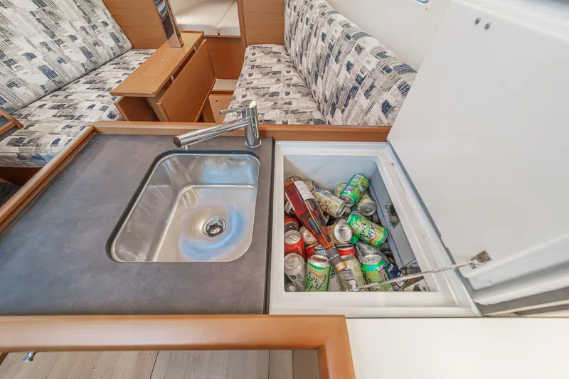 Slide: The Image of Jeanneau Sun Odyssey 349 kitchen sink and cooler with drinks, 2022 model interior. - 33