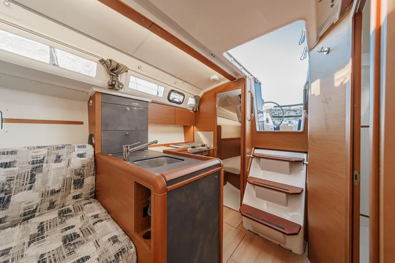 Slide: The Image of Interior of 2022 Jeanneau Sun Odyssey 349 sailboat, featuring modern kitchen and seating area. - 38