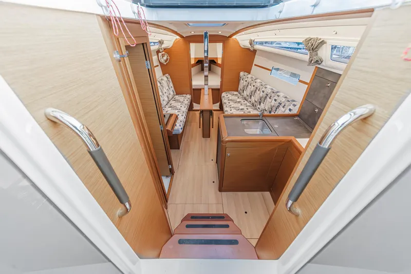 Slide: The Image of 2022 Jeanneau Sun Odyssey 349 interior with modern wood finish and cozy seating area. - 40