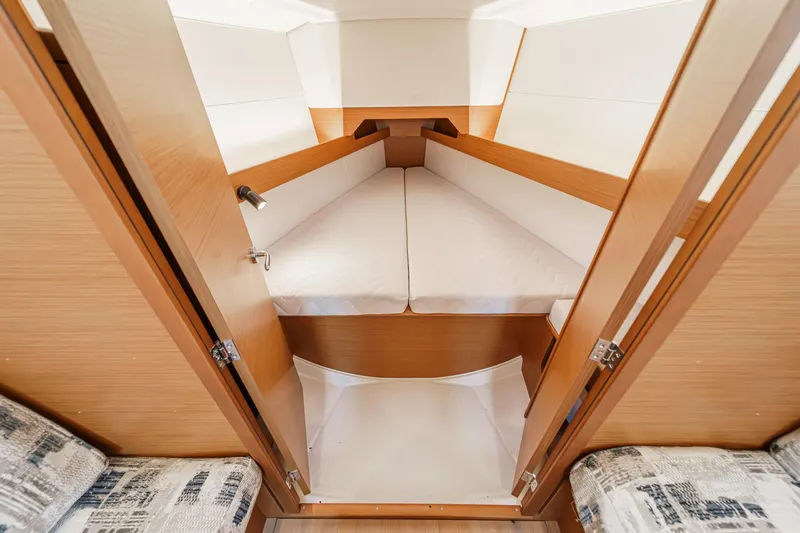 Slide: The Image of 2022 Jeanneau Sun Odyssey 349 cabin interior with cozy bedding and wooden finish. - 9