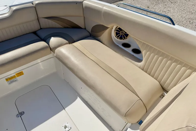 Slide: The Image of 2014 NauticStar 243DC Sport Deck boat interior with beige seating and cup holders. - 12