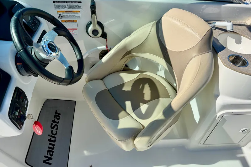 Slide: The Image of 2014 NauticStar 243DC Sport Deck boat interior with steering wheel and captain's chair. - 13