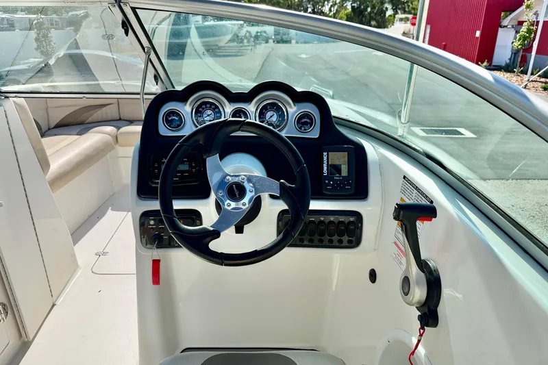 Slide: The Image of 2014 NauticStar 243DC Sport Deck boat dashboard with steering wheel and gauges. - 14